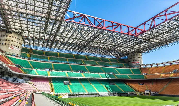 Bên trong sân vận động San Siro với khán đài hùng vĩ và mặt cỏ xanh mướt, sẵn sàng cho trận đấu.