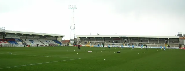 Cầu thủ Hartlepool United khởi động trên sân Victoria Park trước trận đấu, thể hiện không khí chuẩn bị cho ngày thi đấu.