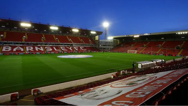 Góc nhìn cận cảnh mặt sân cỏ xanh mướt và khán đài chính của sân vận động Oakwell, sẵn sàng cho trận đấu Barnsley FC