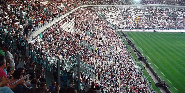 Góc nhìn khán đài phía Đông (Tribuna Est) của sân vận động Allianz Stadium, nơi hàng nghìn cổ động viên Juventus theo dõi trận đấu.