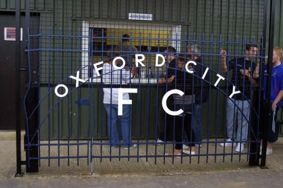 Hàng rào và biển hiệu của sân vận động Oxford City FC, mang dấu ấn lịch sử.