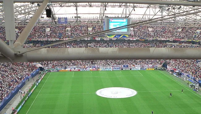 Khung cảnh mặt sân Veltins-Arena xanh mướt nhìn từ khán đài cao, sẵn sàng cho những trận cầu đỉnh cao