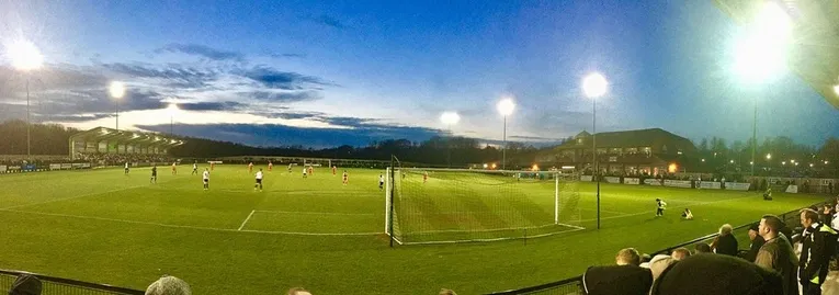 Khung cảnh sân Blackwell Meadows rực rỡ dưới ánh đèn vào ngày thi đấu, sống động tinh thần bóng đá Anh.