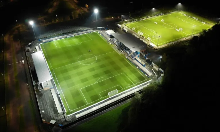 Khung cảnh sân Tameside của Curzon Ashton FC rực rỡ dưới ánh đèn đêm.