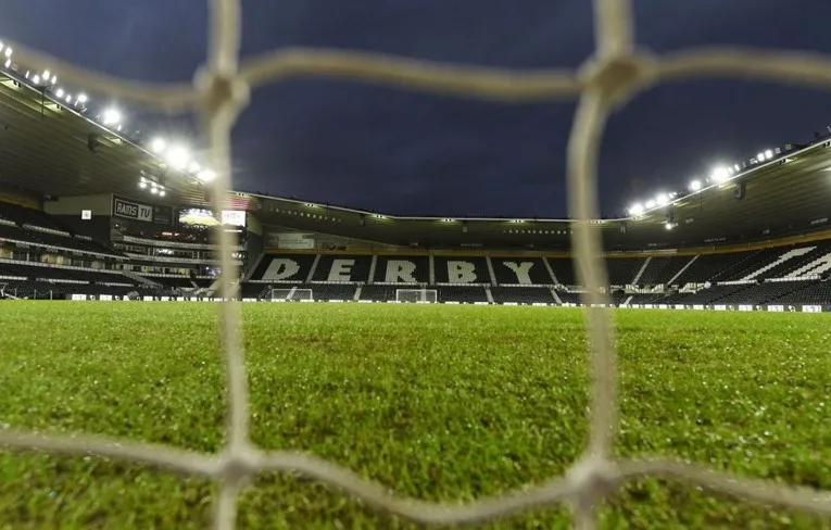 Khung cảnh sân vận động Pride Park nhìn qua lưới khung thành, một góc nhìn độc đáo của trận đấu bóng đá