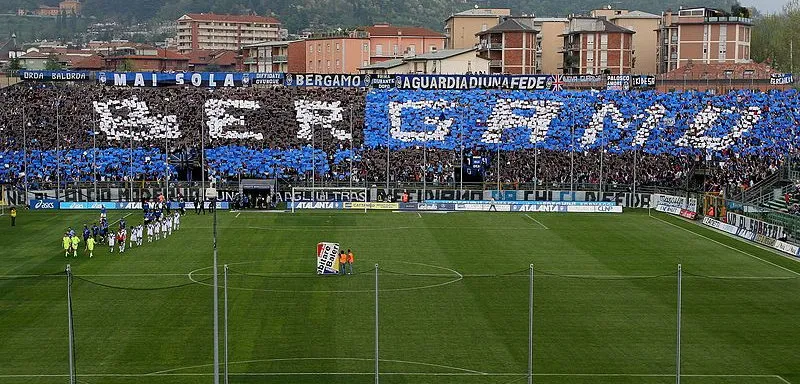 Khung cảnh sôi động một trận đấu tại sân Gewiss Stadium của Atalanta, với khán đài đông kín cổ động viên